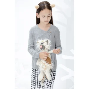 Deklica drži plišasto mačko Kiez Miez znamke Sigikid, ki izžareva ljubek in zabaven značaj z edinstvenim čupastim videzom.